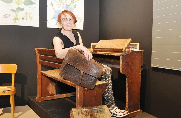 Romy Studerus von der Kommission «Kultur in Fislisbach» drückt fürs Foto noch einmal die Schulbank. Auf so einem harten Bänkli lernten Schülerinnen und Schüler um 1900. Es ist eines der ältesten Exponate der Ausstellung. Fotos: ml