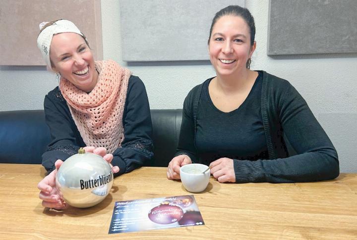 Es gab viel zu organisieren, zu koordinieren und auch zu lachen: Wenige Tage vor dem Weihnachtsmarkt liegen eine Sponsoring-Kugel und der Flyer für den Weihnachtsmarkt vor Sabrina Berlinger (links) und Karin Ebner. Foto: hhs