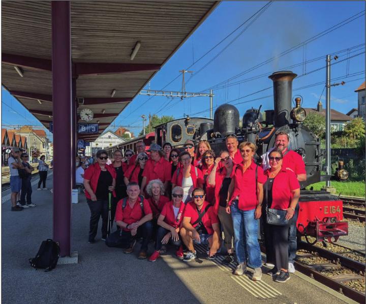 Die Mitglieder der Bühne Mägenwil während ihrer Reise im Bahnhof Saignelégier mit dem Dampfzug im Hintergrund. Foto: zVg