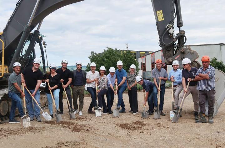 Vertreter der am Bau beteiligten Unternehmen, der Spitex Heitersberg und Anwohner am Spatenstich für den Gewerbepark Gheid. Vierter von rechts Bauherr Mark Käppeli. Im Hintergrund liegt die Industriestrasse. Foto: mbe