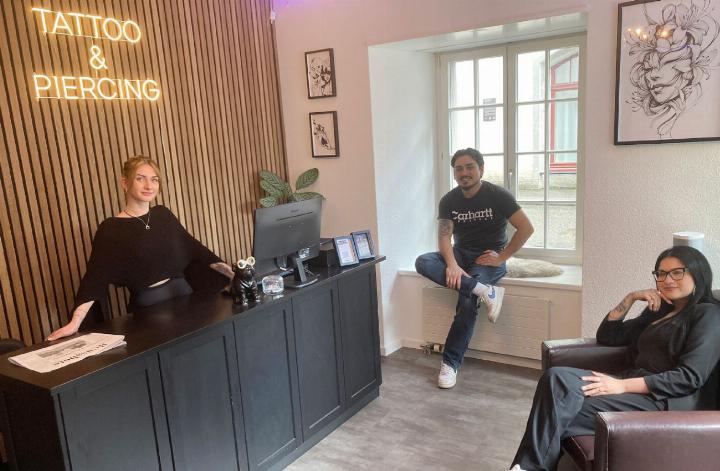 Sie arbeiten vorerst nebenberuflich im Start-up namens Rolling Edge Ink: Noemi Mathis, Bryan Anliker und Zahra Hussain in ihrem Studio (v. l.). Kleines Bild: Auf diesem Stuhl nimmt die Kundschaft Platz fürs Piercing-Stechen. Fotos: mbe