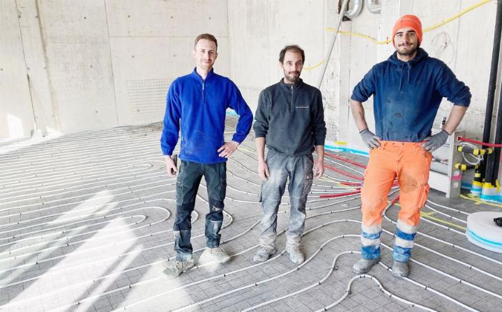 «Wir erstellen die Unterlagsböden», sagt Luciano Bruno (l.), dessen Firma auf Bodentechnik spezialisiert ist. Er und seine Mitarbeiter waren diese Tage am Dorfplatz am Werk. Unten sieht man die Bodenheizung des Lokals. Fotos: mbe