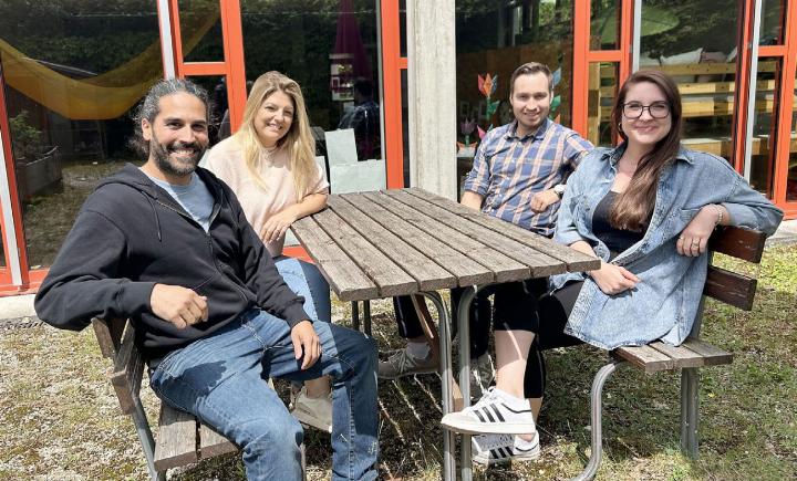 Marvin Kingsley, Tülin Hamurtekin, Silvan Herzig und Jugendarbeiterin Vanessa Battistini (v. l. n. r.) sitzen im Garten des künftigen Kinder- und Jugendtreffs in der Schule in Mägenwil. Foto: hhs