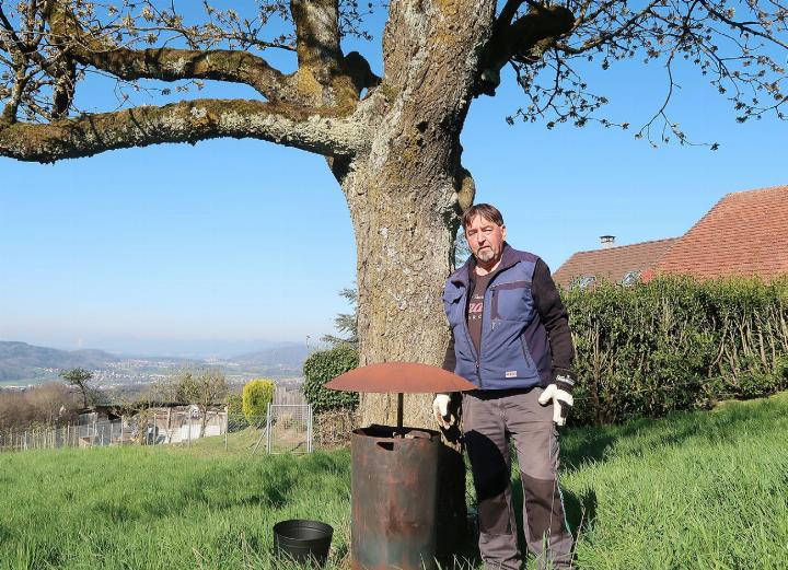 Hans Schären unter einem blühenden Kirschbaum mit dem von ihm erfundenen Anti-Frostofen. Fotos: mbe