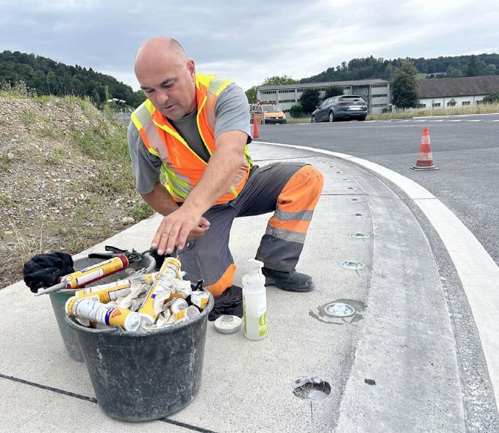 Beim Kreisel Birrfeldstrasse setzt Slavisa Sandic von der Wettinger Grabag AG sogenannte «Roadmarker»: 144 Lichter in ebenso viele Löcher. Foto: hhs