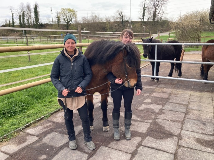 Trainerin Seraina Isler (links) und Sara Frischknecht (rechts), welche Demantur (7) am Donnerstag ausritt. Sie stürzte und wurde leicht verletzt. Im Hintergrund sieht man den Hügel, wo der Unfall passierte.Foto: mbe Trainerin Seraina Isler (links) und Sara Frischknecht (rechts), welche Demantur (7) am Donnerstag ausritt. Sie stürzte und wurde leicht verletzt. Im Hintergrund sieht man den Hügel, wo der Unfall passierte.Foto: mbe