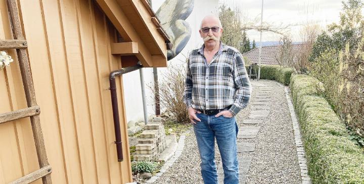 Fridolin Koch hinter seinem Haus. Er ist mit seiner Familie vor acht Jahren von Fislisbach nach Remetschwil gezogen. Die Vorschrift der Grünflächenziffer sei ein starker Eingriff ins Eigentum, findet er. Foto: mbe