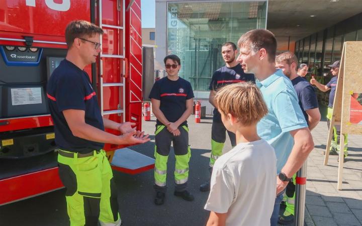 Matthias Schibli (l.) unterhält sich mit einem Besucher, um ihn und seinen Sohn über die Feuerwehr zu informieren und sie zu begeistern. Fotos: mbe