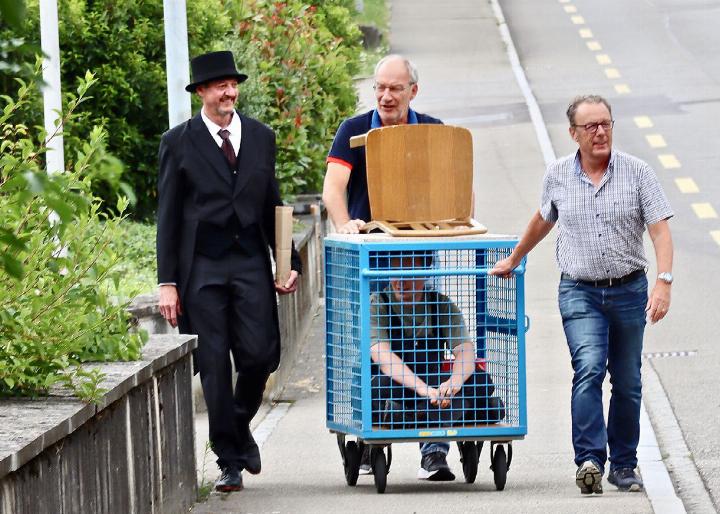 Ernst und würdevoll fuhren der Gautschmeister (links) und die beiden Packer den Gautschling Gergey Steinacher im Gitterwagen von der Nüssli Druck AG zum Johanni-Brunnen in der Altstadt von Mellingen.