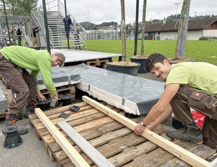Samuel Meyer und Marko Petrusic installieren den Holzboden beim Stand des Gartenbauunternehmens Jenni und Partner. Auf die Holzkonstruktion werden zu Demonstrationszwecken Steinplatten gelegt. Fotos: hhs