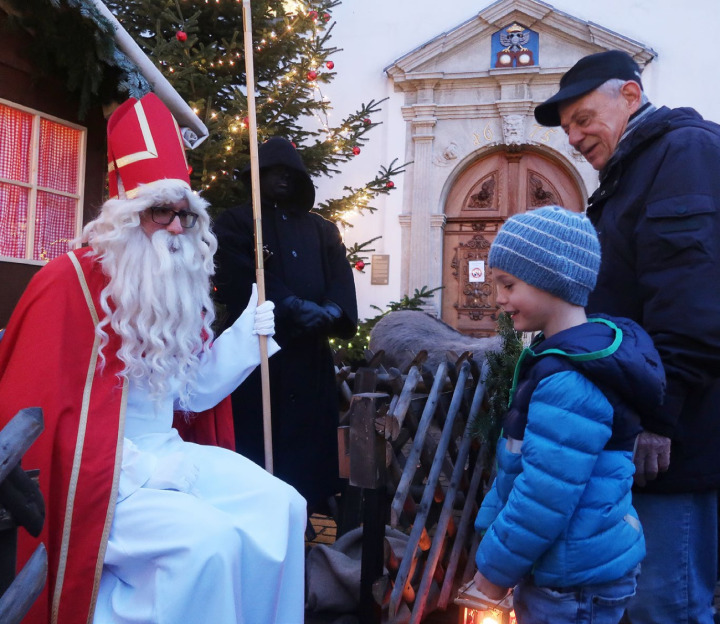 Der Samichlaus hört Linus aufmerksam zu, als dieser «Jupii, de Samichlaus isch doo» vorträgt. Rechts der Grossvater.