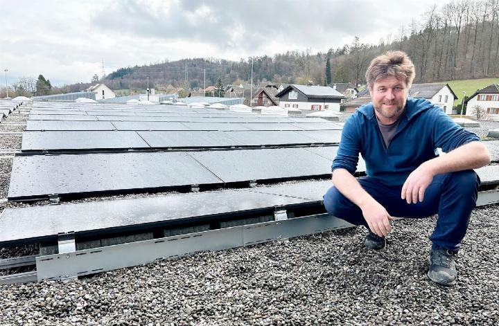 Matthias Geissmann, Schulhauswart, neben der neuen Photovoltaikanlage auf dem Schulhausdach, die seit einer Woche Strom für die Schule und weitere Häuser der Gemeinde liefert. Foto: hhs
