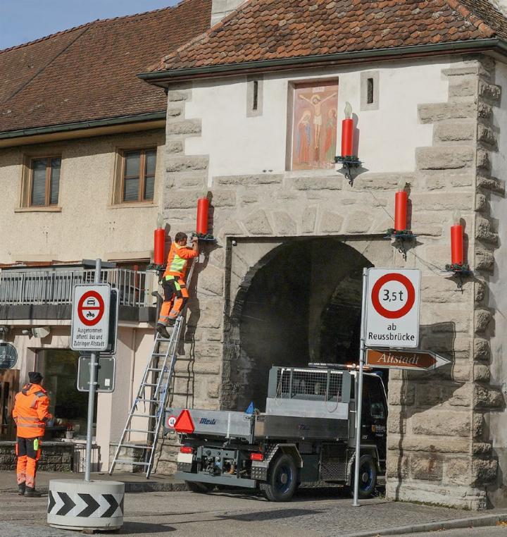 Werkdienstmitarbeitende hängten am Dienstag die Weihnachtsbeleuchtung mit 169 roten Kerzen in der Altstadt auf. Foto: Viktor Zimmermann