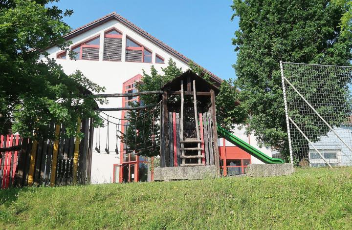 Grosses Bild: Das Siegerprojekt sieht einen Erweiterungsbau auf dieser Seite des Schulhauses rot vor. Auf dem kleinen Bild ein Modell des Architekturbüros Kollektiv Marudo, das an der Gemeindeversammlung ausgestellt war; in der Mitte das Schulhaus rot mit dem Erweiterungsbau rechts, unten links das Schulhaus gelb. Fotos: mbe