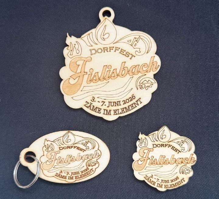 Die Dorffest-Plakette ist draussen. Oben auf dem Bild die Gönnerplakette und unten die Ansteckplakette als Schlüsselanhänger oder Pin. Fotos: zVg