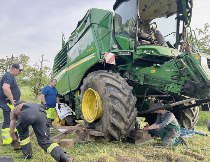 Der Mähdrescher steht wieder. Weil die Räder aber von den Felgen weggedrückt wurden, versuchen Landmaschinenmechaniker, Feuerwehrleute und das Abschlepp-Team die Vorderräder wieder fahrtüchtig zu machen Fotos: hhs