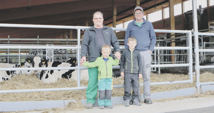 Drei Generationen: Toni Peterhans (l.) mit Sohn Daniel (r.) und seinen Enkeln Roman (4) und Fabian (6) vor dem neuen Freilaufstall. Die Holsteinfarm hat verschiedene Standbeine. Eines davon ist die Milchwirtschaft. Fotos: dg/zVg