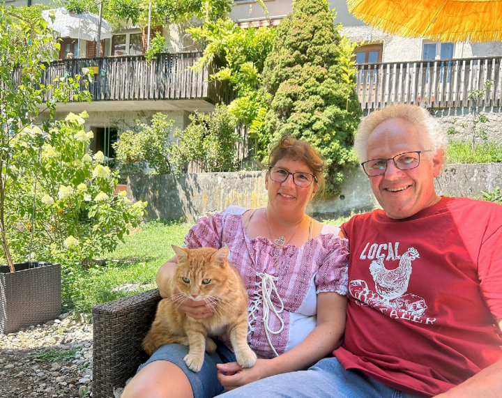 Monika und Vinzenz Hunn mit Büsi «Garfield» in ihrem Garten auf dem Lindenhof in Stetten. Sie sind mit ihrer Familie die Gastgeber beim 1.-August-Brunch in Stetten: «Einige wenige Plätze sind noch frei», sagen sie. Foto: hhs