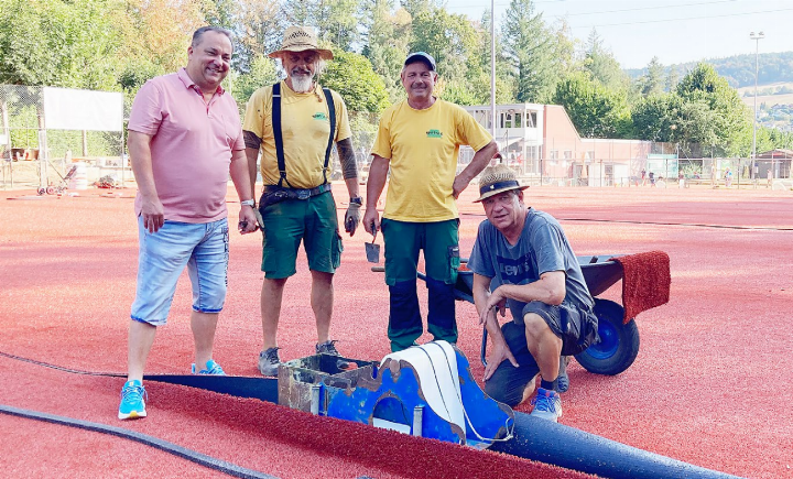 Vereinspräsident Benjamin Merkli (links) und Platzwart René Düsel (rechts) mit Mitarbeitern der Spezialfirma, die auf den neuen Allwetter-Tennisplätzen die Linienmarkierungen verkleben. Der Platzwart begleitete die rund fünfwöchigen Arbeiten und legte beim Aushub und beim Verlegen der neuen Wasserleitungen auch selbst Hand an. Foto: ml