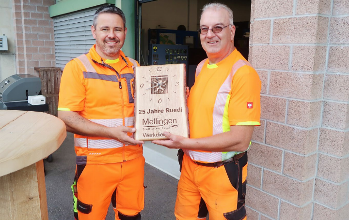Der Leiter Werkdienst, Severin Kamm (links) überreicht Ruedi Schraner ein Geschenk der Gemeinde. Es ist eine gewidmete Uhr mit Wappen auf einem fein bearbeiteten Brett, das aus einem Baumstamm geschnitten wurde. Fotos: mbe